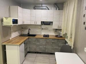 a small kitchen with white cabinets and a sink at Apartments Апартамент Рабочая 81, Кирова Kirova in Dnipro