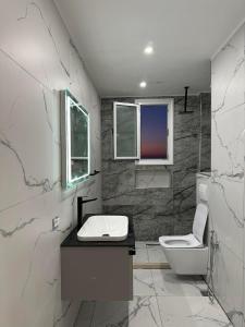 a white bathroom with a sink and a toilet at Sea View Apartment Luxury in Vlorë +31 photos