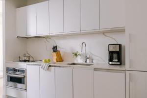 uma cozinha branca com um lavatório e um micro-ondas em Sonder Battery Park em Nova Iorque