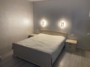 a small bedroom with a bed and two night stands at Apartments Апартамент Рабочая 81, Кирова Kirova in Dnipro