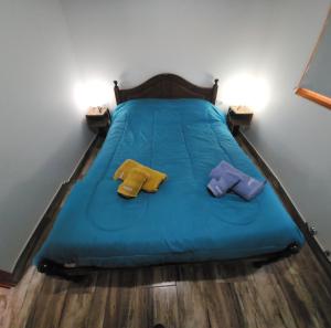 Una cama con dos manoplas sentada encima. en Cabaña SANTA MONTAÑA en Ushuaia