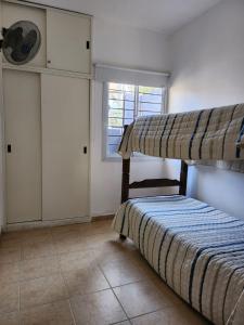 1 dormitorio con 2 literas y ventana en AMSTERDAM DEPARTAMENTOS en Villa Carlos Paz