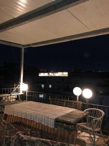 stół i krzesła na balkonie w nocy w obiekcie Lemon Tree Terrace w mieście Neapol +27 zdjęć