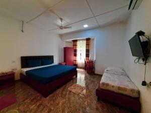 een slaapkamer met een bed en een flatscreen-tv bij villaflorence in Kadawata