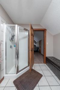 a walk in shower with a glass door in a room at Raven in Valemount