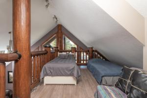 Schlafzimmer im Dachgeschoss mit einem Bett und einem Fenster in der Unterkunft Raven in Valemount