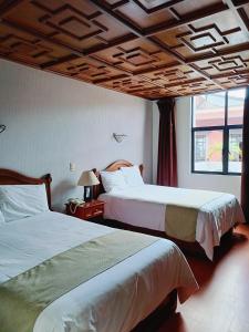 a bedroom with two beds and a window at HOTEL VIRREYNAL in Teziutlán