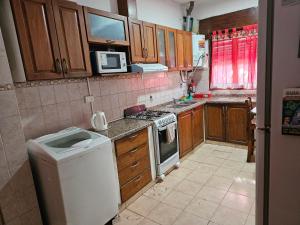 a small kitchen with a stove and a microwave at Casa, hogar equipado para el viajero y su familia. in Cordoba