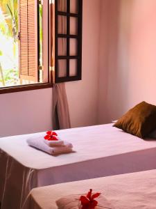 een kamer met twee bedden met rode bloemen erop bij Casa Ramildes Paraty flat 5 in Paraty