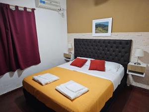 a bedroom with a large bed with two towels on it at Casa, hogar equipado para el viajero y su familia. in Cordoba