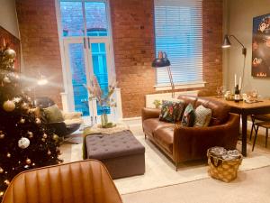 Una sala de estar con un árbol de Navidad y un sofá. en The Fifth Quarters, Grade II Listed Apartment, The Lace Market, NG1, City Centre, Nottingham, Sleeps 4, en Nottingham