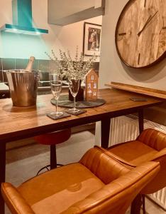 a kitchen with a table with wine glasses and a clock at The Fifth Quarters, Grade II Listed Apartment, The Lace Market, NG1, City Centre, Nottingham, Sleeps 4 in Nottingham