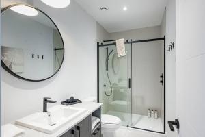 een badkamer met een douche, een wastafel en een spiegel bij Modern Luxurious Chalet near Tremblant in La Conception