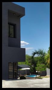 una casa negra con piscina y sombrilla en AMSTERDAM DEPARTAMENTOS en Villa Carlos Paz