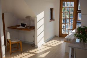 a room with a bed and a laptop on a desk at Loft with views in Cape Town