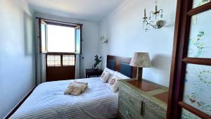 1 dormitorio con cama y ventana en Casa con jardín y jacuzzi, en Realejo Alto