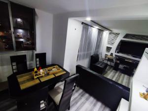 Precioso apartamento completo con tina y equipado في Soacha: غرفة معيشة مع أريكة وطاولة في غرفة