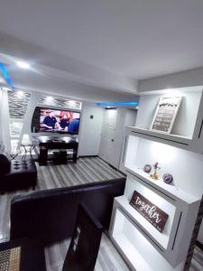 a living room with a couch and a tv at Precioso apartamento completo con tina y equipado in Soacha