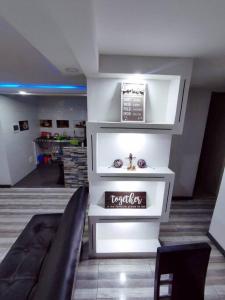 Precioso apartamento completo con tina y equipado في Soacha: غرفة معيشة مع رفوف بيضاء وأريكة