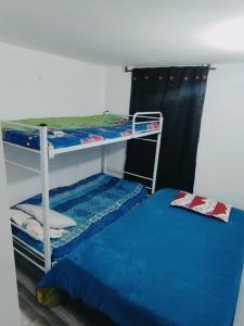 Precioso apartamento completo con tina y equipado في Soacha: غرفة نوم بسريرين بطابقين وسرير ازرق