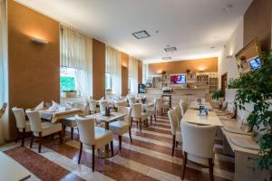 プラハにあるプラハ センター プラザのテーブルと椅子のあるレストラン、キッチンが備わります。