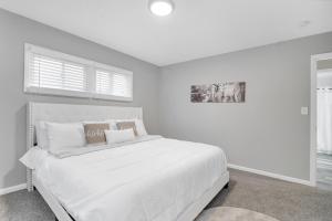 a white bedroom with a large white bed at Relax and Play in Akron