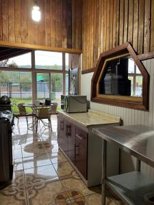 a kitchen with a counter and a table with a microwave at Hostel del Valle in Recinto
