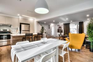 kuchnia i salon z dużym białym stołem w obiekcie Lux. 4BR House with Pool near DT w mieście Brossard