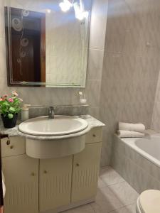 a bathroom with a sink and a tub and a mirror at APARTAMENTO SARDINERO - CÉNTRICO RH SANTANDER in Santander