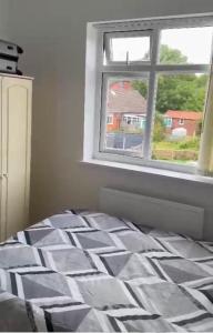 a bedroom with a bed and a window at BLESSED HOME in Bolton