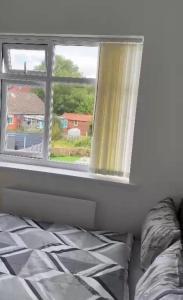 sypialnia z łóżkiem i oknem w obiekcie BLESSED HOME w mieście Bolton