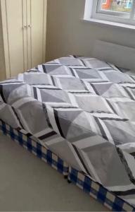 a bed with a blue and white comforter at BLESSED HOME in Bolton