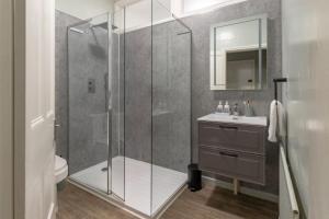 a bathroom with a shower and a sink at Clarence Square Penthouse 