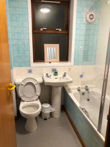 Cosy flat, Scalloway في Scalloway: حمام مع مرحاض ومغسلة وحوض استحمام