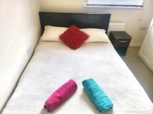 a bed with two colored pillows on top of it at The Haven Comfort in Harold Wood