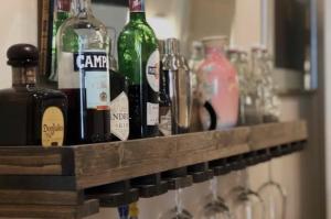 a row of wine bottles and glasses on a shelf at Apartamento Bonito Zona Sul in Porto Alegre
