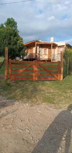 una valla de madera frente a una casa en Cabañas Monika - Alta en Huerta Grande
