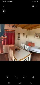 Habitación con mesa, sillas y cama en Cabañas Monika - Alta en Huerta Grande