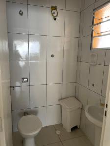 a small bathroom with a toilet and a sink at Paraíso Particular in Itanhaém +27 photos