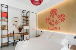 a bedroom with a white bed with a red painting on the wall at tèmporas Design Rooms in Cagliari