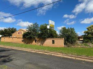 a building with a sign on the side of it at Three Ways Motel in Gilgandra