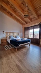 sypialnia z łóżkiem w pokoju z drewnianym sufitem w obiekcie Casa Luenga w mieście Vinuesa