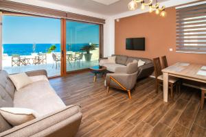 a living room with a couch and a table and a dining room at Sunset Bay Apartments in Utjeha