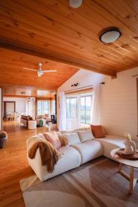a living room with a white couch and wooden ceilings at Nunyara - Mountain Views, Rural, Kangaroos, Birds 