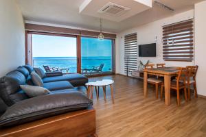 a living room with a couch and a table at Sunset Bay Apartments in Utjeha