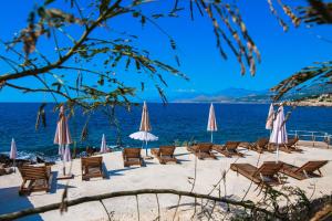 a group of chairs and umbrellas on a beach at Sunset Bay Apartments in Utjeha