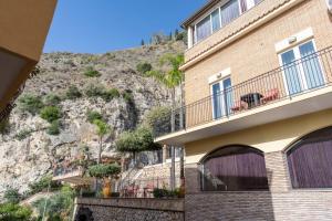 a building with a mountain in the background at Hotel Corallo in Taormina