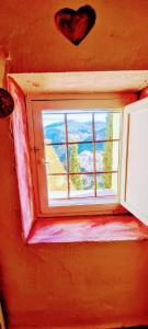 a window in a red room with a heart on the wall at La Ronda in Cuenca