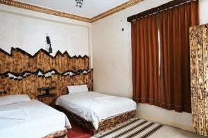 a bedroom with two beds and a window at Dounia Hostel in Tinerhir