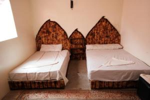 um quarto com duas camas num quarto com a estrita e estrita em Dounia Hostel em Tinghir